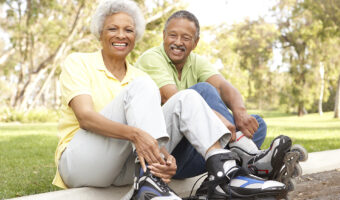 An elderly couple rollerblading together.