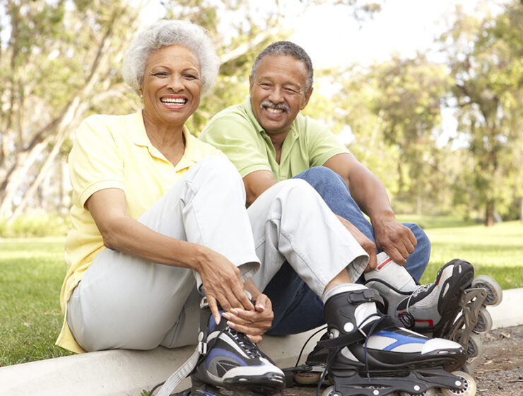 An elderly couple rollerblading together.