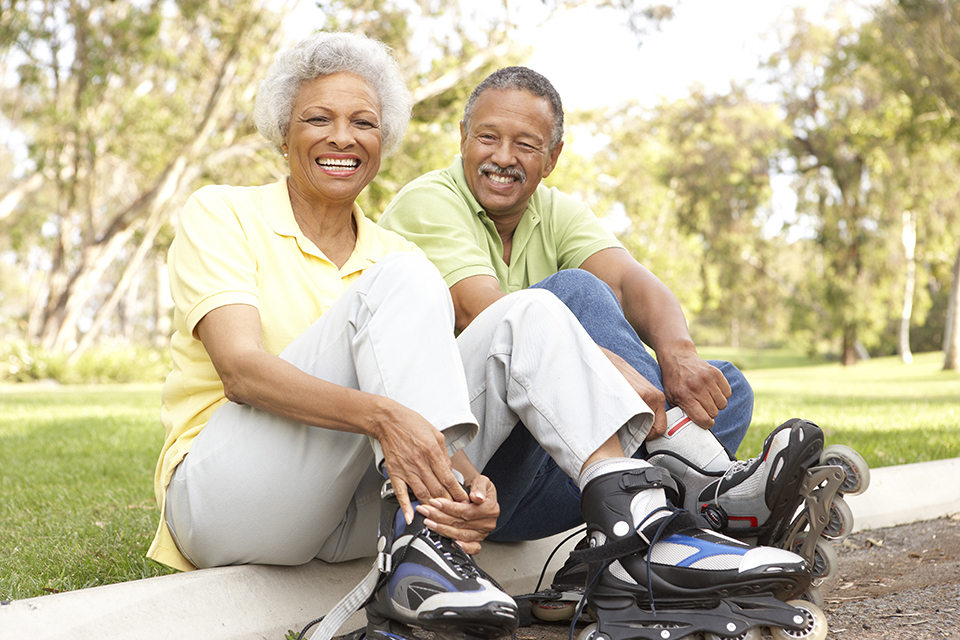 An elderly couple rollerblading together.